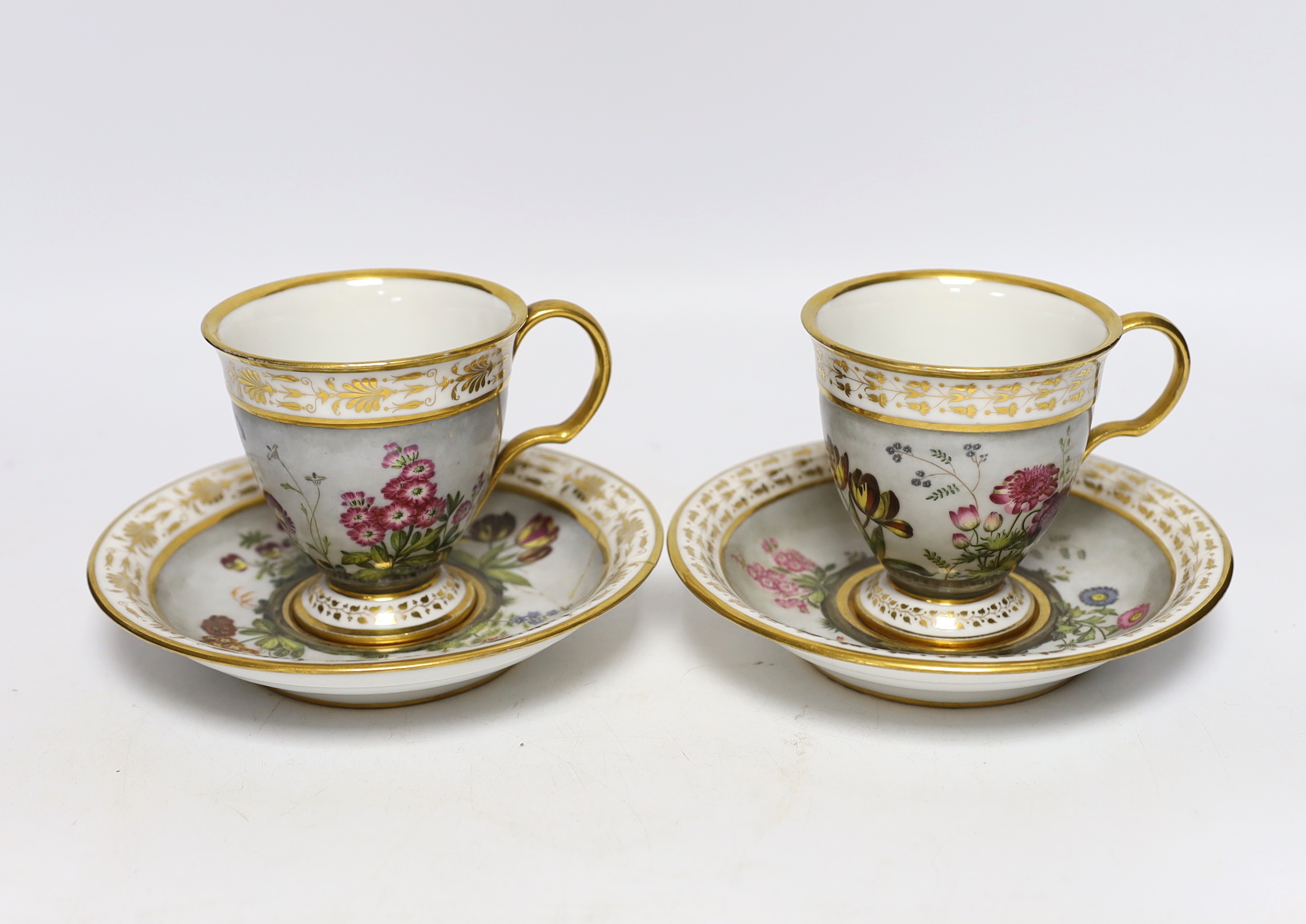 A pair of early 19th century Paris porcelain botanical cups and saucers, one signed Dihl, 9cm high